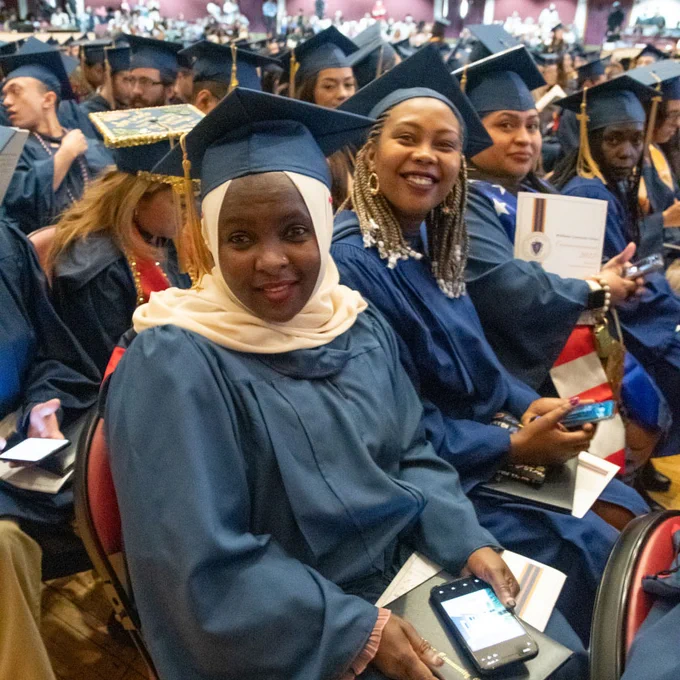people wearing caps and gowns sit in audience
