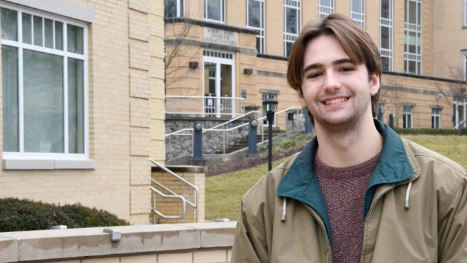 Eli Hall stands in front of Ikenberry Hall at Shepherd University.