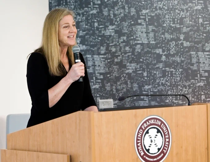 Dr. Lise Eliot presenting behind a podium