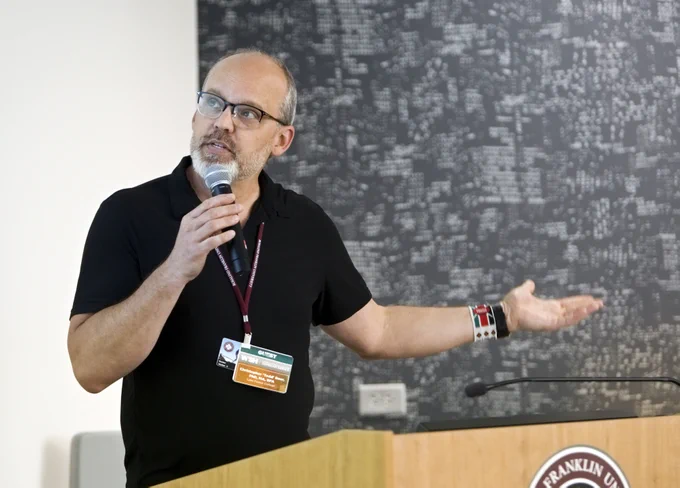 Dr. Christopher "Todd" Beer presenting behind a podium