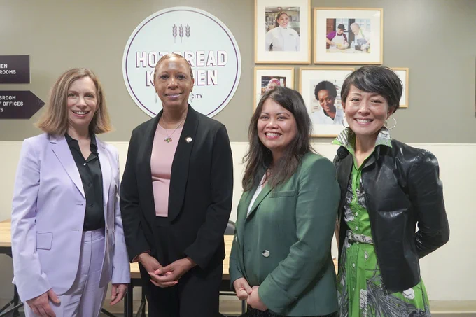 Speaker Adams posing for a photo with three staff members from hot bread kitchen