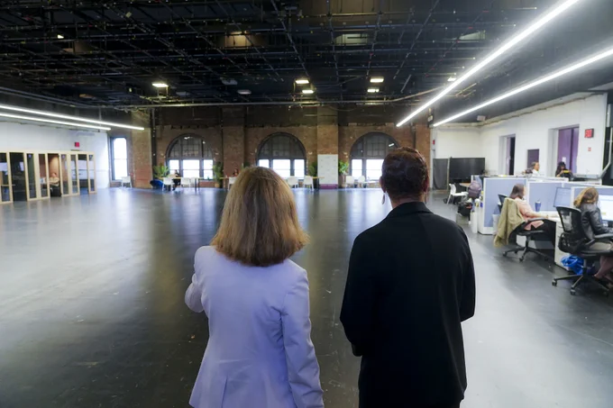 The back of Speaker Adams and another woman as they look at an open space