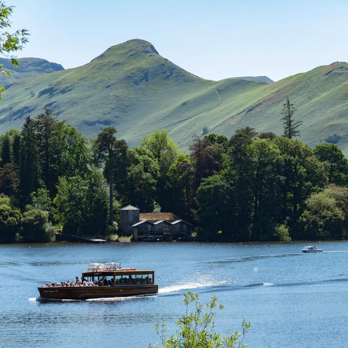 a small boat in a body of water with a mountain in the background