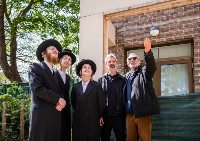 The architect and members of the community looking at the new homes