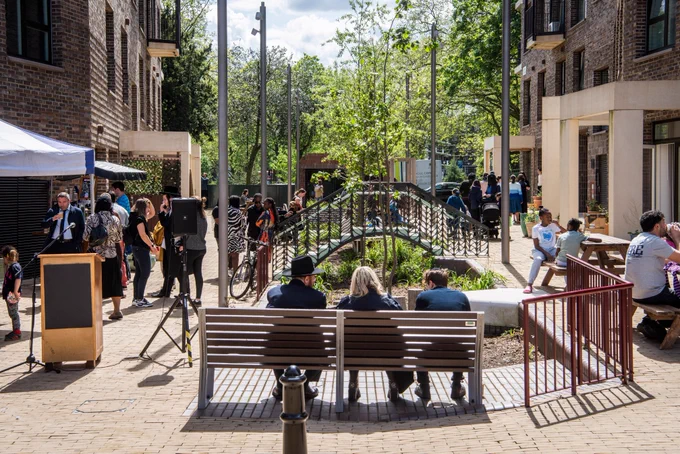 A bench surrounded by landscaping at Tower Court with neighbours and members of the community socialising 