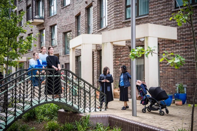 A family standing on the bridge surrounded by the new homes