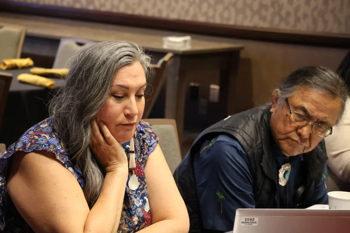 IAC Co-Chairs Eileen Briggs (Cheyenne River Sioux Tribe) and Robert Yazzie (Navajo Nation) share a laptop during the May 2024 meeting.