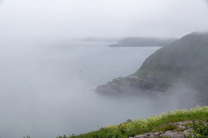 Fort Amherst, a former defense of St. John's harbour in Newfoundland, is seen through a thick layer of fog from the top of Signal Hill. 