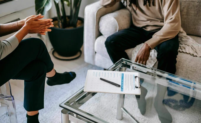Two people sat in a room talking 