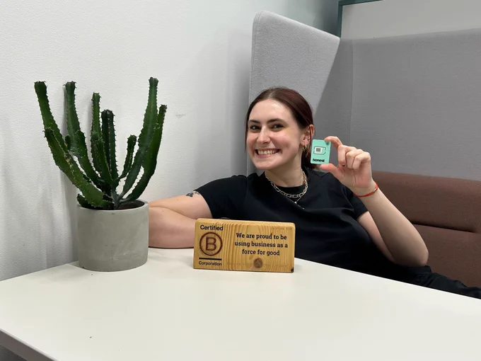 Anna modelling an Honest SIM next to our B Corp logo