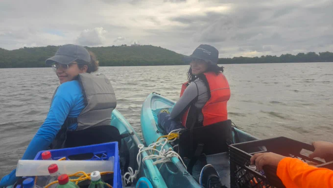 Students in kayaks on Laguna grande with crates holding bottles, ropes, and other equipment for water sampling