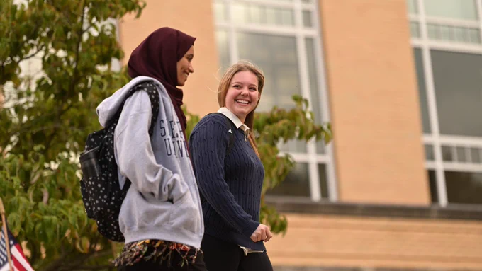 Two Shepherd University students walk from the Robert C. Byrd Center for Congressional History and Education.