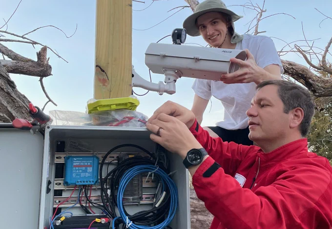 Troy Gilmore (bottom right), associate professor in UNL’s School of Natural Resources, and Chris Terry, undergraduate student at the University of Nebraska at Kearney, work on a U.S. Geological Service camera at the Kearney Outdoor Learning Area as part of GRIME Lab research.