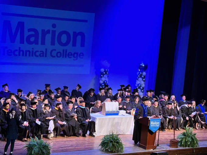 The board, faculty and staff are on the stage at the start of the graduation ceremony.