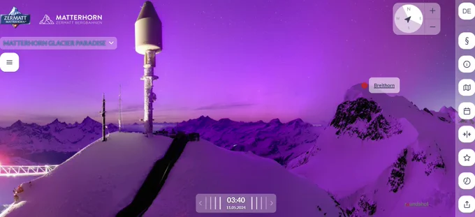 purple-blue sky over snow and mountains, with icy construction gear in foreground