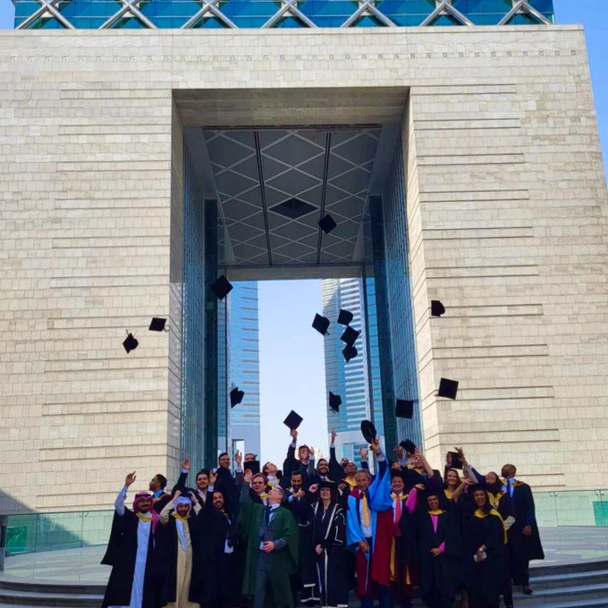 A photo of a group of students throwing their graduation caps in the air