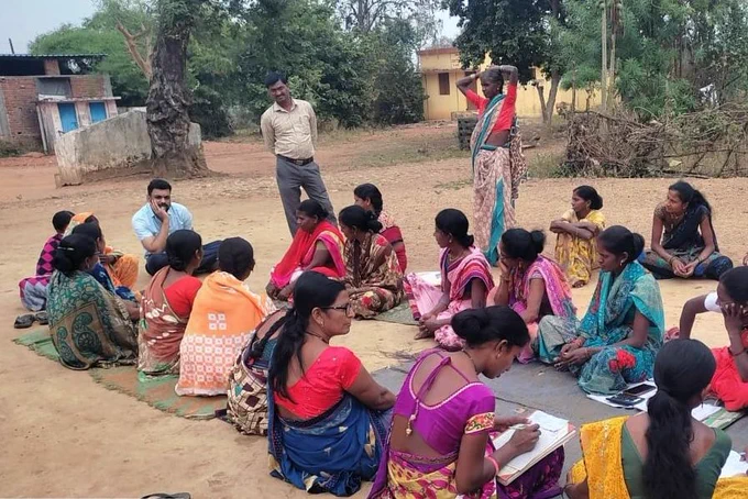 Kasim Saiyyad sits with women who participate in MGNREGS work.