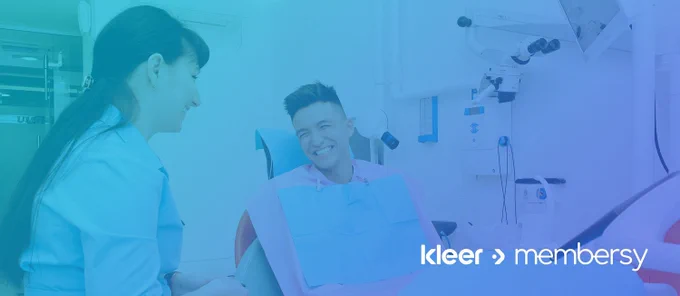 A male patient smiling at a female dentist in an exam room, overlaid with the logos "kleer" and "membersy.