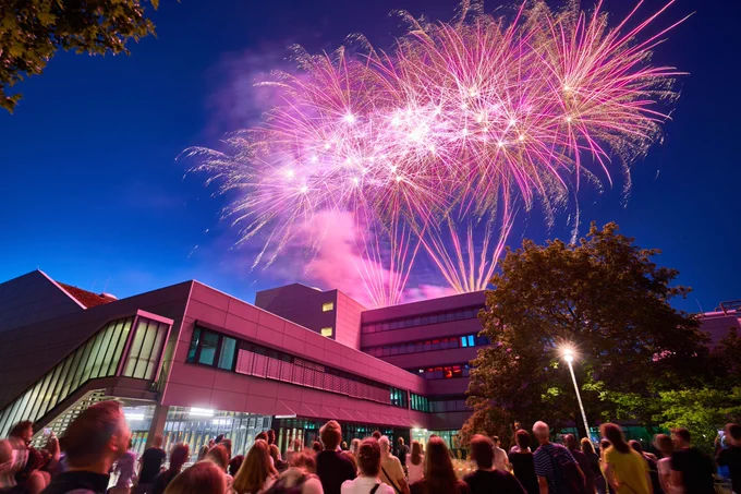 Menschen betrachten das Feuerwerk über dem Haus Bauwesen auf dem Campus der BHT in der Langen Nacht der Wissenschaften