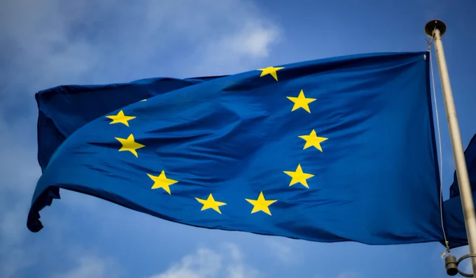Photo by Christian Lue on Unsplash. Flag of the European Union in front of the EU-Parliament in Brussels, Belgium
  