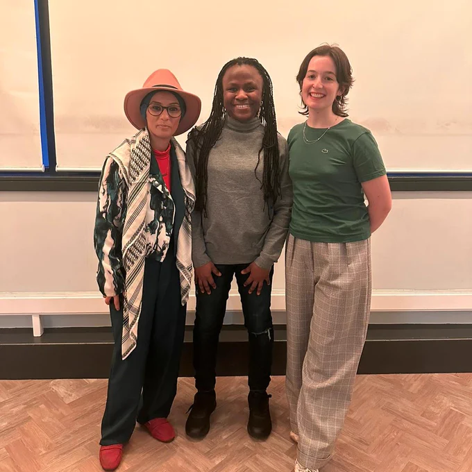 An image of three people stood smiling
