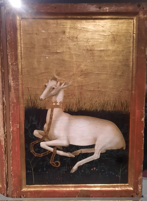White Hart lying on flowery meadow. Behind the Hart, the background is solid gold leaf