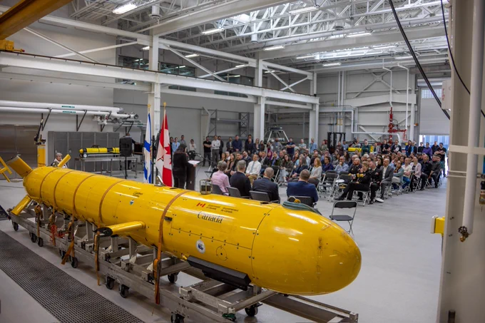 An uncrewed underwater vehicle is displayed before an audience.