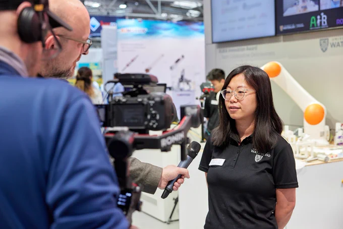 Photo of Dr. Yue Hu talking to an interviewer