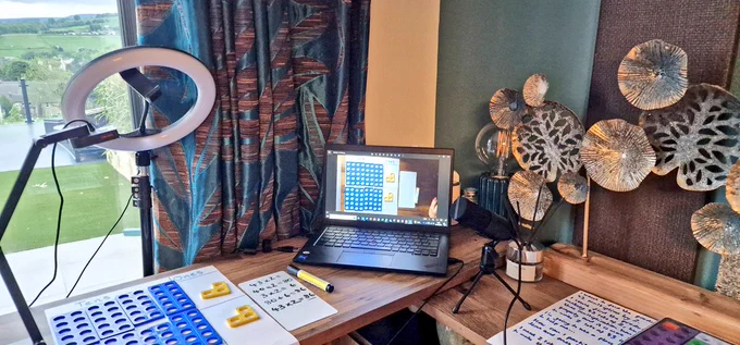 Desk with numicon manipulatives on. With a visualiser, ring light and laptop. 