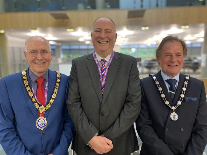 From left to right - Newly elected Chair Cllr Pat Hanlon in blue suit, and chain of office, Outgoing Chair Cllr Roger Dicker in grey suit and newly elected Vice Chair Cllr Phil Wittam in dark suit with chain of office.