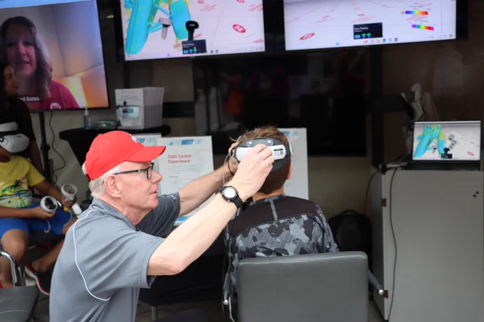 Ohio Supercomputer Center staff member helps visitor view virtual reality content. 