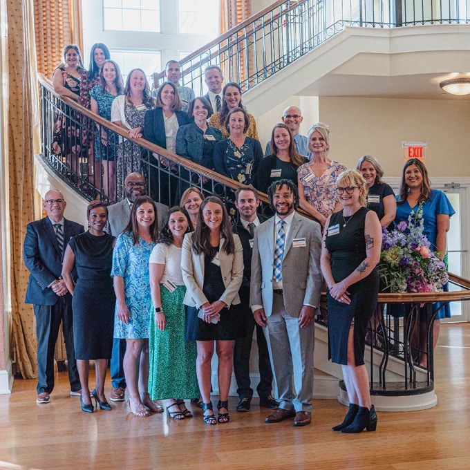 teachers pose for a photo on a staircase