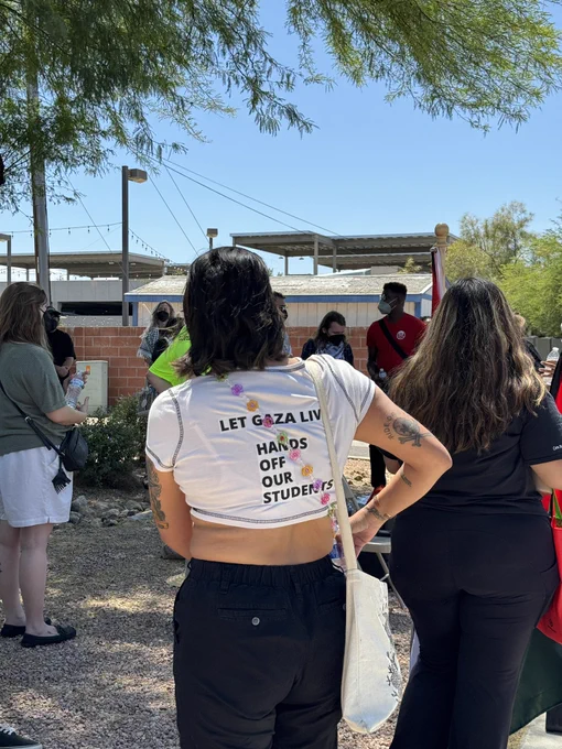 A person stands at a Mass Liberation Arizona-organized rally on May 14, 2024, to support people arrested during ASU’s Liberated Zone protest for Palestine. The back of their shirt reads, “Let Gaza live hands off our students.”