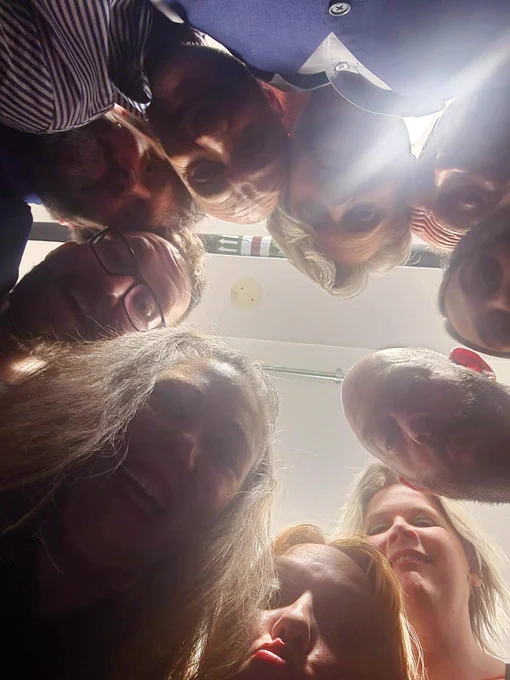 Nine people all looking down at the camera from above.