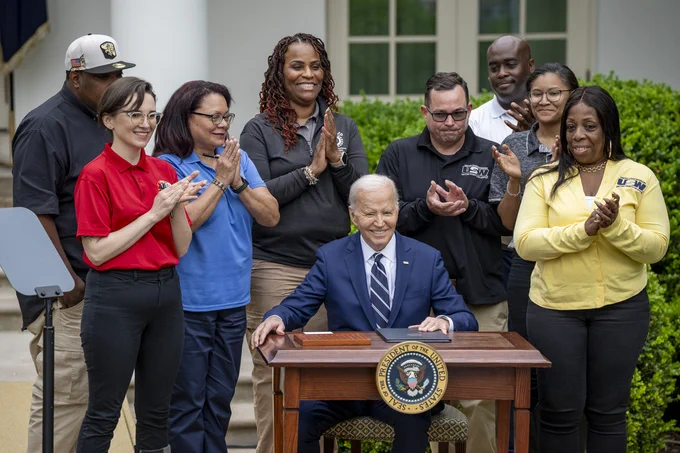 President Biden signs a new rule into law in the Rose Garden.