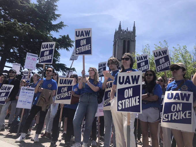 Crowd of UAW members holding picket signs in front of Gerberding Building