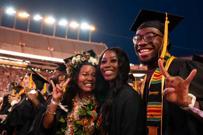 Three graduates pose for a photo together 