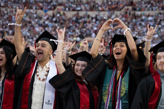 Graduates cheering and smiling during commencement 
