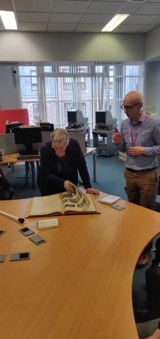 Craig showing a service user a record book 