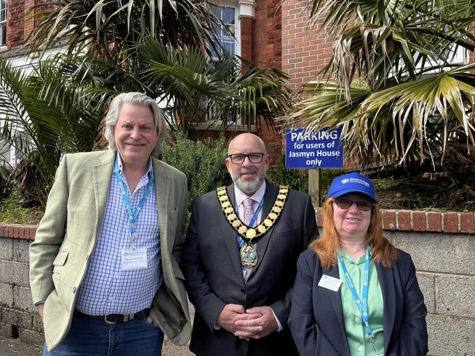 The image is a picture of Grahame Flynn Chief Executive Officer, Devon in Sight, Cllr Mark Spacagna, The Mayor of Torbay and Mandy Darling, Community Engagement and Fundraising Officer, Devon in Sight. They are standing outside Jasmyn House where we held our Living Well with Sight Loss Event in Torbay. The Mayor is wearing his Chain of Office.