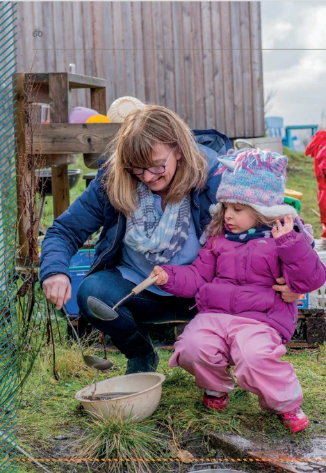 Adult and child using ladles to pour water into a bowl outside