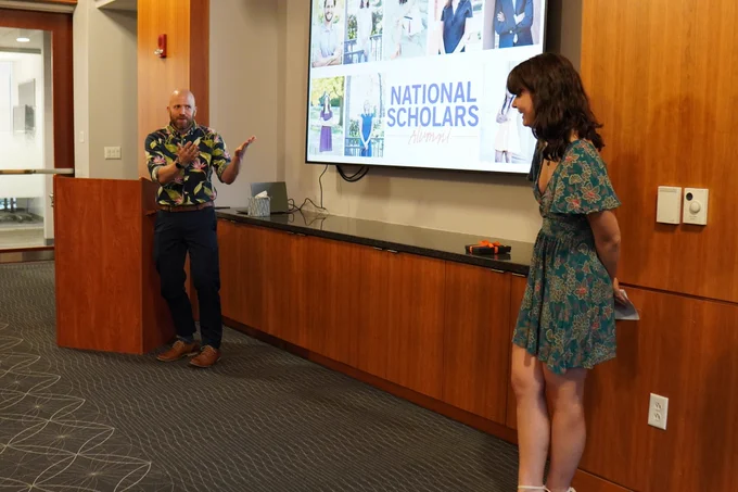 A picture from the dinner, with Dr. Matt Voigt next to the podium, his student to the right-hand side of the projector screen.