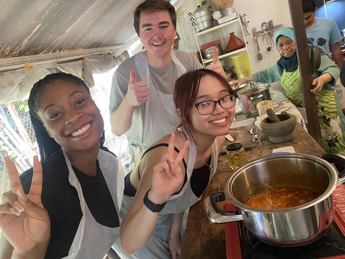 Three students pose with their laksa