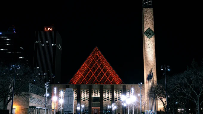 The pyramids of City Hall lit in red at night.