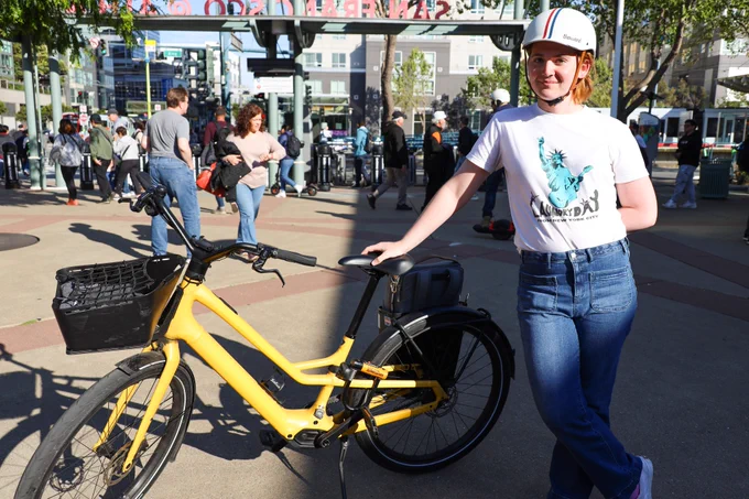 bike rider posing with her yellow bike at 4th and king