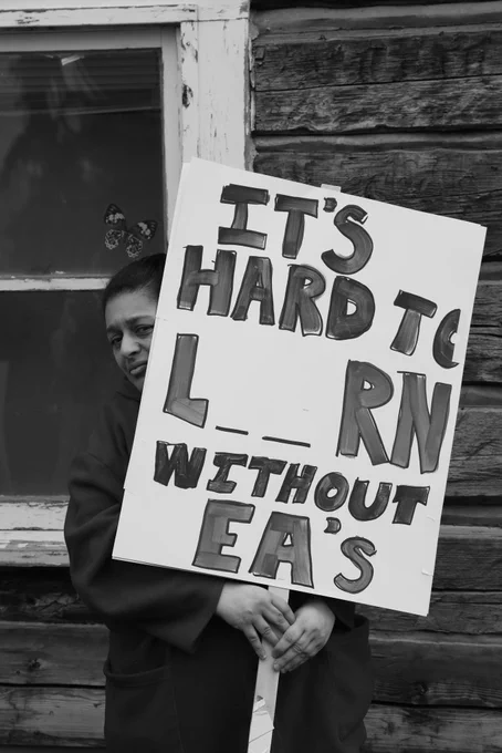 Protester with a sign that reads "It's hard to L__RN without EA's."