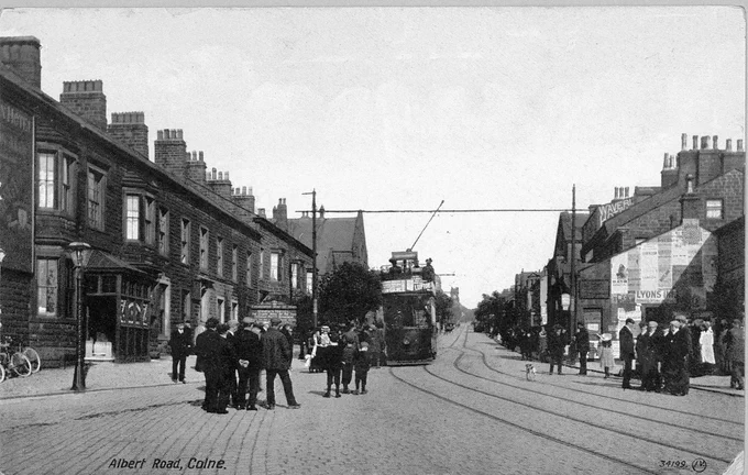 Black and white photo of Albert Road, Colne (c. 1910) showing the tram and people on the street