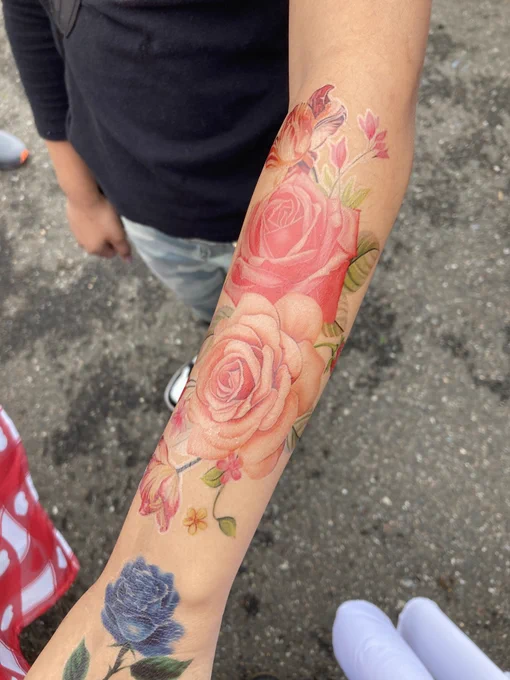 A large rose temporary tattoo on a child's arm.
