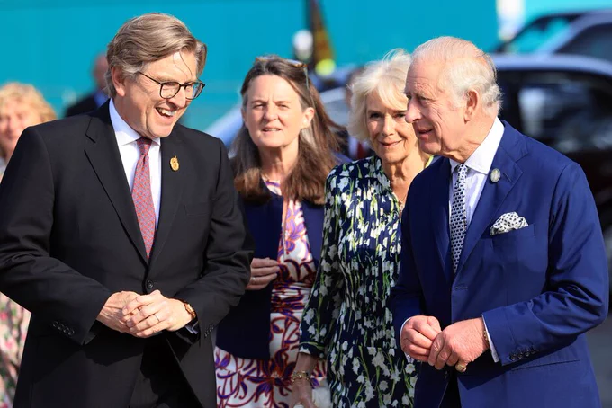 The King and Queen smiling as they walk along with RHS President Keith Weed and Director General Clare Matterson