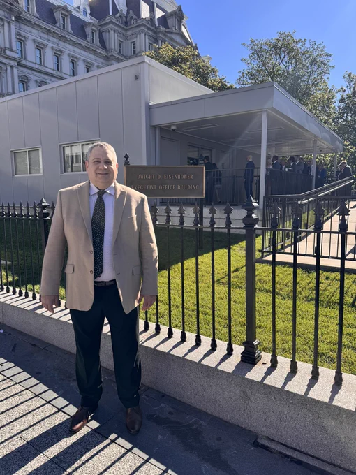 Joe Devon, co-founder of Global Accessibility Awareness Day, smiles while standing in front of the Dwight D. Eisenhower Executive Office Building in Washington, DC, before speaking at a GAAD event at the White House.